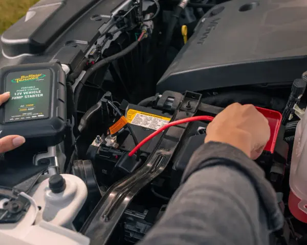 A person connects a Battery Tender jump starter to a car battery. This answers the question: do jump starters come charged?