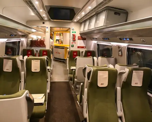 Wnętrze wagonu PKP Intercity. Puste zielone fotele czekają na pasażerów. Pamiętaj, że pkp intercity bilet bez gwarancji miejsca do siedzenia może oznaczać podróż na stojąco.