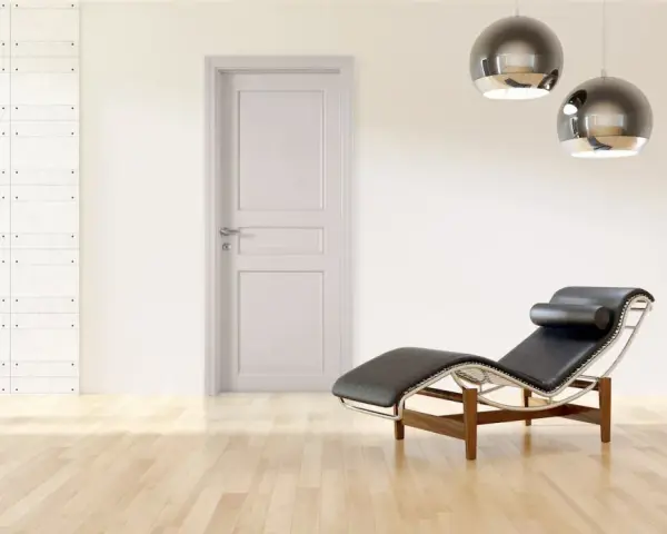 Divano in pelle nera e metallo, con un'elegante porta tortora e un muro con texture geometrica. Un perfetto abbinamento tortora e verde per un ambiente moderno.