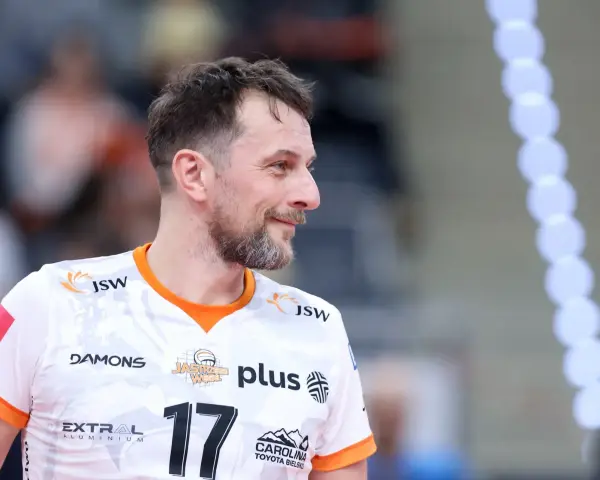 Uśmiechnięty rozgrywający w siatkówce, z numerem 17 na koszulce, gotowy do gry.
