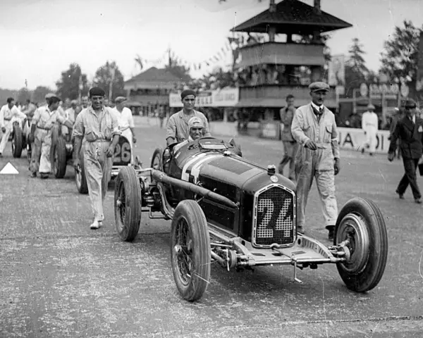 Tazio Nuvolari, leggenda dell'automobilismo, con la sua Alfa Romeo numero 24, pronto a sfrecciare.