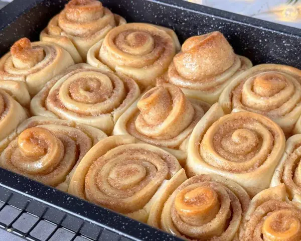 Frisch gebackene Zimtschnecken im Blech, bereit für das Zimtschnecken Rezept Original. Saftig und duftend.