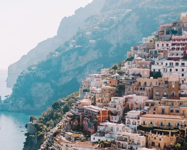 Colorful buildings cascade down a cliffside to the sea, a picturesque scene perfect for a 3 month Europe itinerary.
