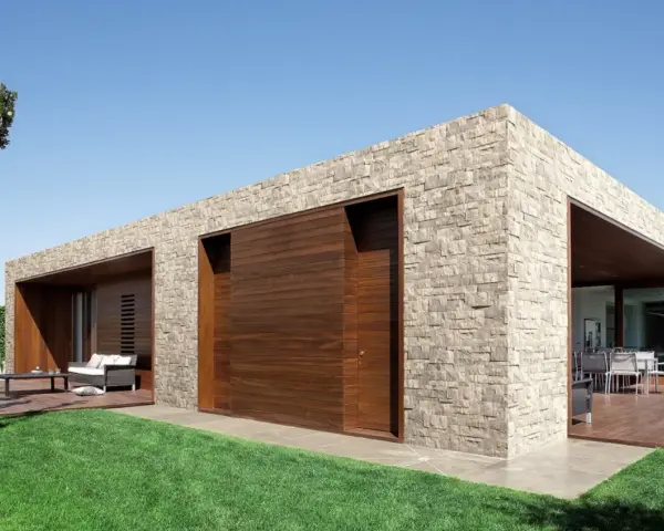 Moderna casa con facciate in pietra e inserti in legno. Un'oasi di design contemporaneo.