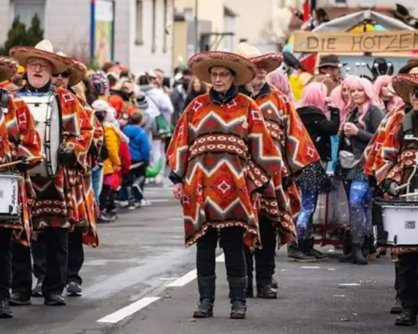Menschen in bunten Ponchos und Sombreros marschieren mit Trommeln. Sie feiern Fasching, eine Zeit voller Freude und Verkleidungen.