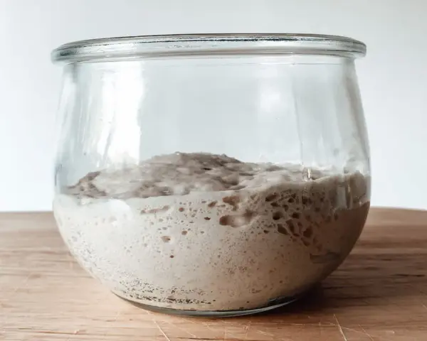 Aktiver Sauerteig im Glas, bereit für ein Lievito Madre Rezept. Blasen zeigen die Gärung.