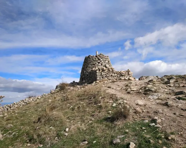 Ruinas de piedra en la cima del **cerro de San Pedro**, bajo un cielo azul con nubes blancas.