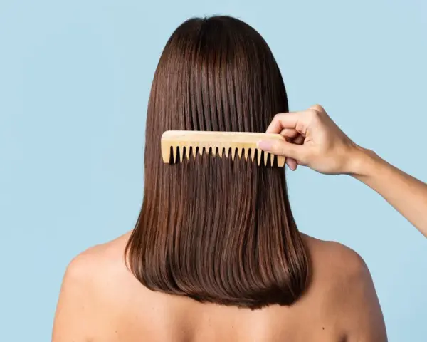 Peinando el cabello castaño para lograr un texturizado pelo perfecto.