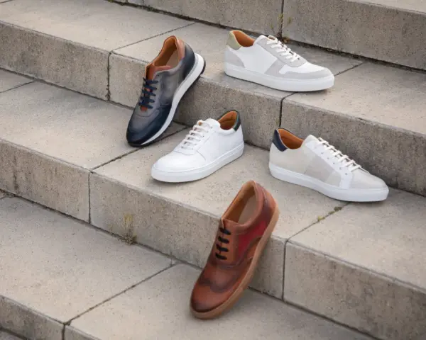 Cinque paia di scarpe eleganti, perfette per un outfit ufficio sneakers. Diverse tonalità di pelle e design moderni.