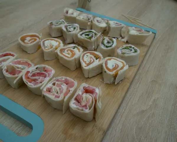 Petits roulés de wrap froid, parfaits pour un apéritif facile. Saumon, fromage frais et herbes se marient à merveille dans cette recette.