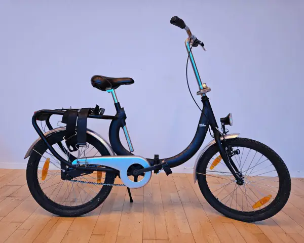 Svart dam cykel med pakethållare och reflexer. Perfekt för stadspendlaren som vill ha en smidig och praktisk cykel.