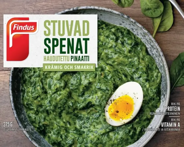 En skål med krämig stuvad spenat, toppad med ett halvt kokt ägg. Findus logotyp syns tydligt.