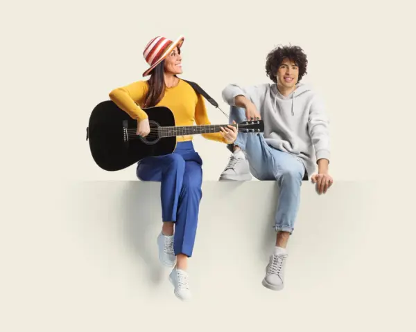 Frau mit Gitarre und Mann sitzen nebeneinander. Sie üben für ihren **spanisch austausch** und singen gemeinsam.