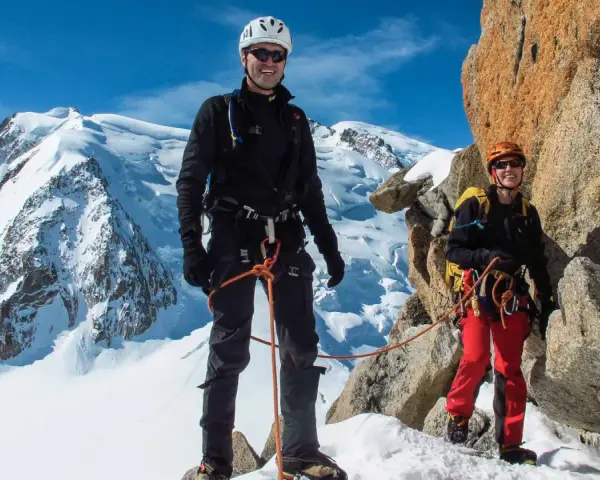Zwei Bergsteiger auf dem Weg zur Mont Blanc Besteigung, umgeben von Schnee und Felsen.