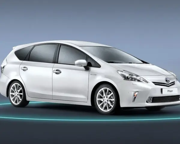 Biały Toyota Prius+ na tle niebieskim. To auto hybrydowe, które oferuje przestronne wnętrze, idealne dla rodziny. Ile miejsc ma ten model?