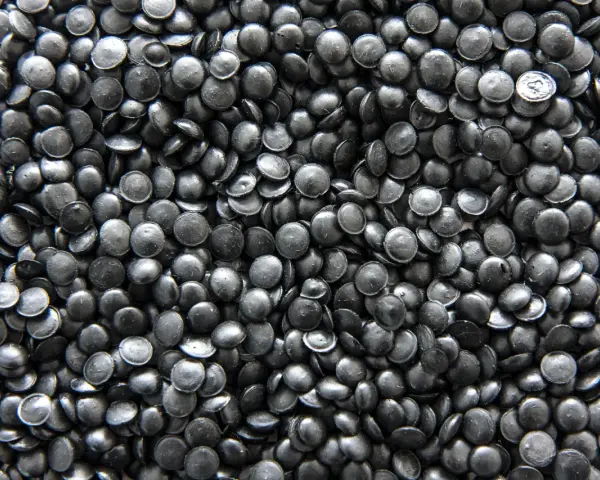 Mnóstwo czarnych granulek regranulatu HDPE, gotowych do przetworzenia w nowe produkty.