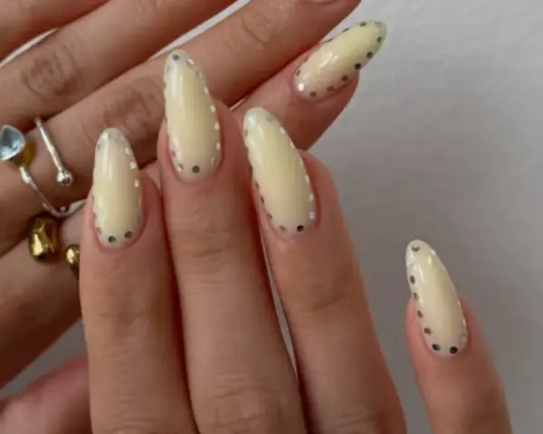 Modne paznokcie wzory galeria: kremowe migdałki z błyszczącymi kropkami. Delikatny manicure, który przyciąga wzrok.