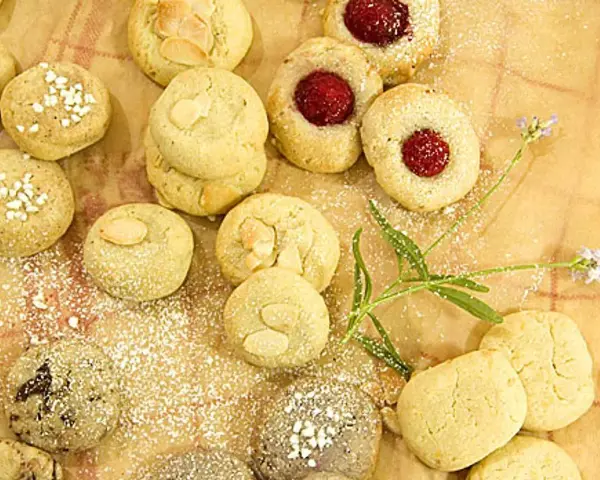 En härlig samling sju sorters kakor recept, pudrade med florsocker. Några med mandel, andra med sylt och några med strössel.