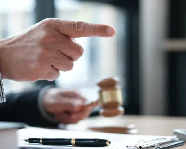 Sędzia wskazuje palcem, młotek sądowy w dłoni. Sprawa dotyczy śmierci wierzyciela a dług.