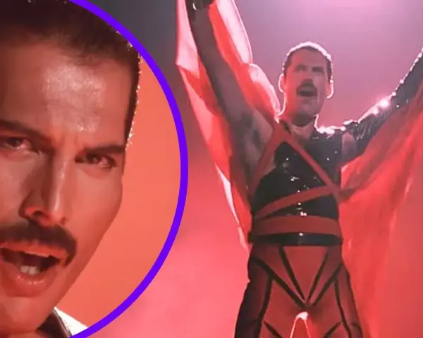 Freddie Mercury w czerwonym stroju, z rękami w górze, promuje swój **freddie mercury solo album**. Obok jego twarz z charakterystycznym wąsem.
