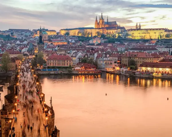 Zachód słońca nad Pragą, tłumy na Moście Karola. Czy do Czech trzeba mieć paszport? Nie, wystarczy dowód osobisty.