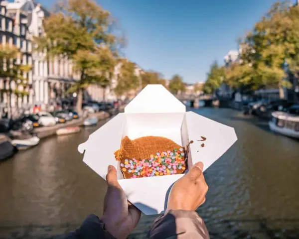 Un delizioso stroopwafel con zuccherini colorati, perfetto da gustare passeggiando lungo i canali di Amsterdam. Ecco cosa mangiare ad Amsterdam!