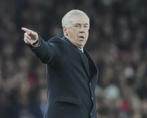 Carlo Ancelotti, con su característico gesto, señala algo en el campo.