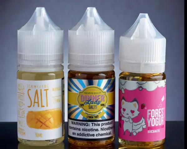 Tres botellas de líquidos para vapear con sales de nicotina: mango, limón y yogur de fresa.