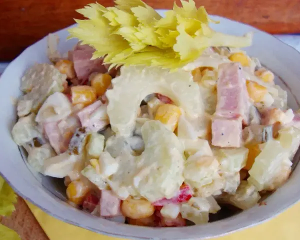 Pyszna sałatka z selerem naciowym, ananasem, kukurydzą i szynką, polana kremowym sosem. Idealna na każdą okazję!