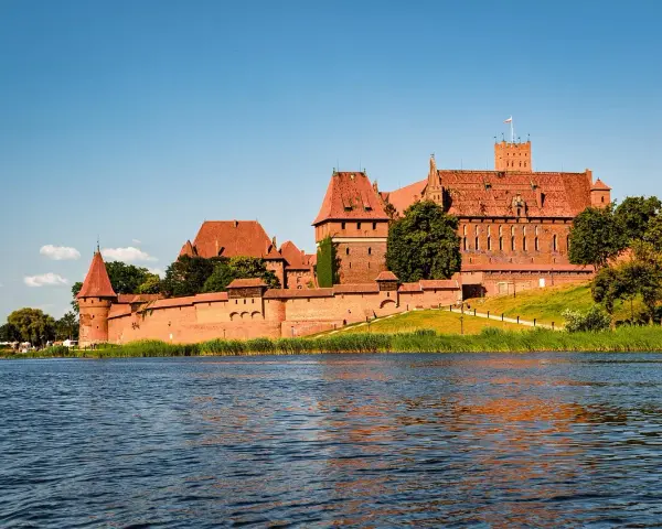 Potężny zamek w Malborku nad rzeką. Zwiedzanie zamku w Malborku to podróż w czasie.