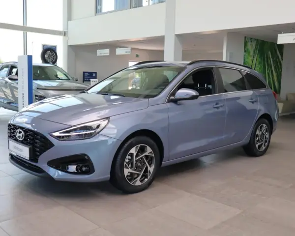 Niebieski Hyundai i30 Wagon z 2015 roku stoi w salonie samochodowym.