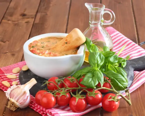 Mortai con pesto alla trapanese, pomodorini, basilico, aglio e mandorle, pronti per un sapore autentico.