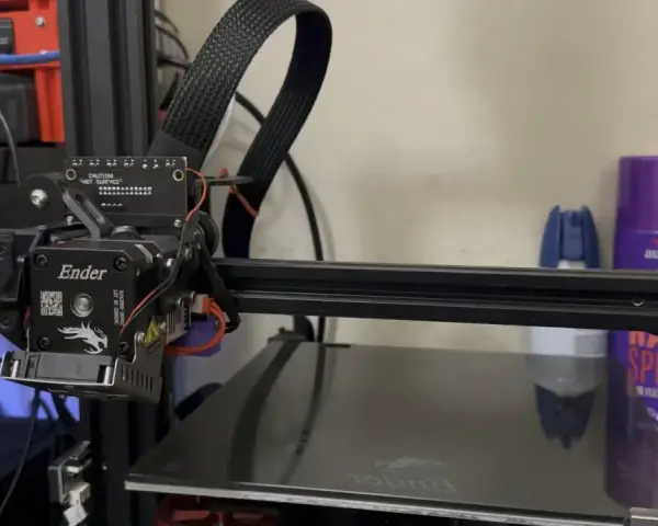 Głowica drukująca klipper ender 3 z kablem w oplocie. Na półce w tle fioletowa puszka z napisem "aussie".