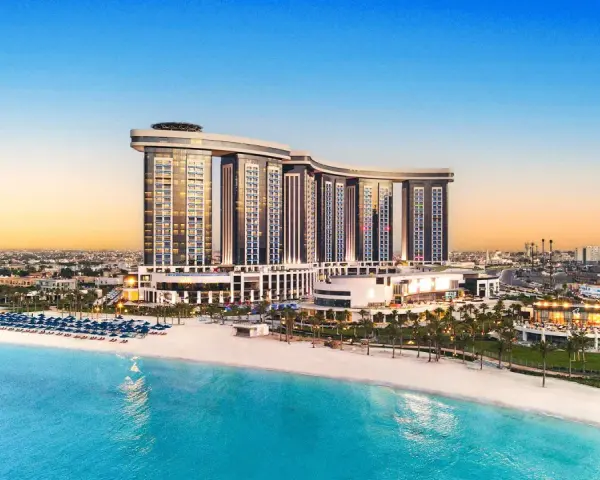 Luksusowy Rixos Premium Alamein z widokiem na turkusowe morze i piaszczystą plażę. Idealne miejsce na wakacje.
