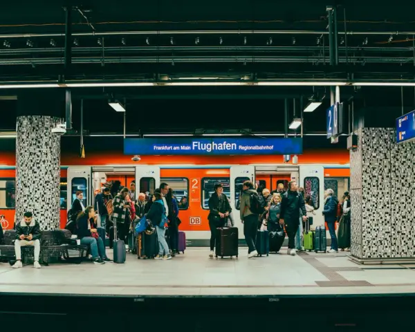 Pasażerowie z bagażami czekają na pociąg na peronie lotniska Frankfurt am Main Flughafen Regionalbahnhof.