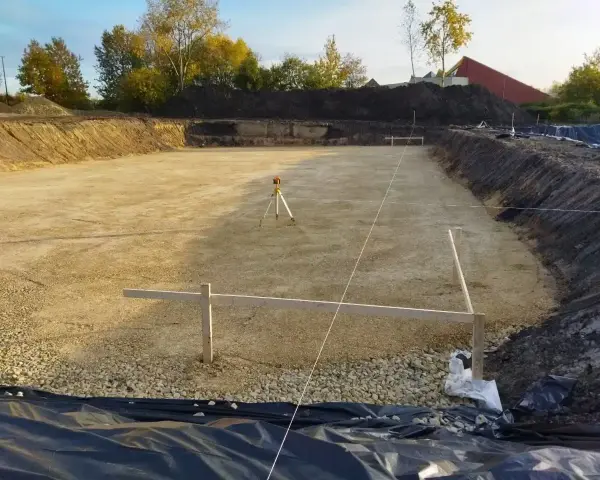 Precyzyjna niwelacja terenu, widoczny niwelator i geodezyjne wyznaczenie prac. Sprawdź niwelacja terenu cena za m2.