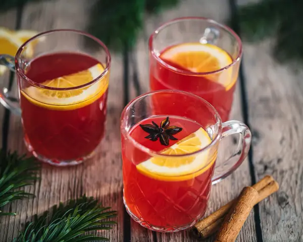 Drei Tassen Kinderpunsch mit Orangenscheiben und Sternanis. Die ideale Temperatur für den Punsch ist warm und einladend.