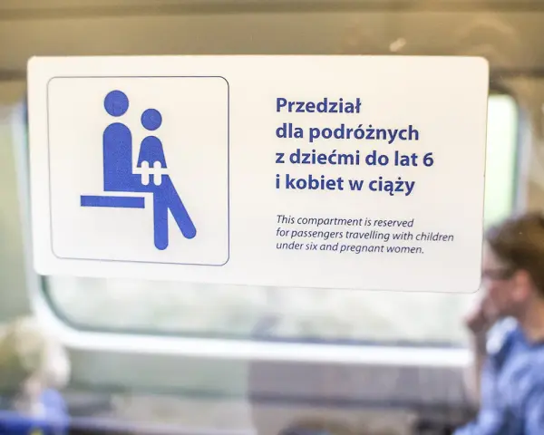 Znak na drzwiach pociągu Pendolino: przedział dla podróżnych z dziećmi do lat 6 i kobiet w ciąży.