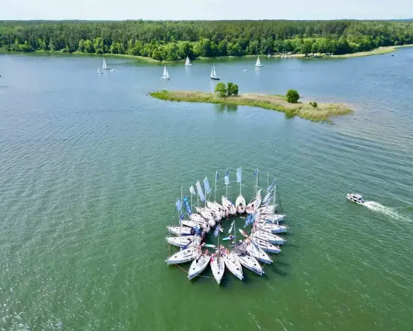 Flota jachtów tworzy okrąg na wodzie, tworząc niezwykły widok na Mazurach.
