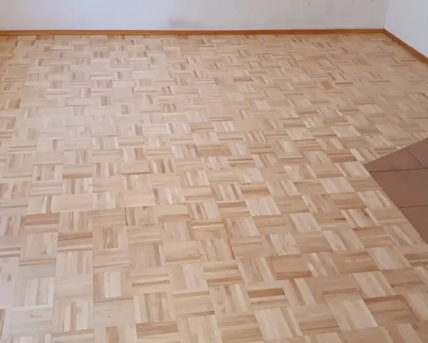 Odnowiony parkiet w jodełkę. Zastanawiasz się, ile kosztuje cyklinowanie parkietu? Ten piękny, drewniany wzór czeka na renowację.