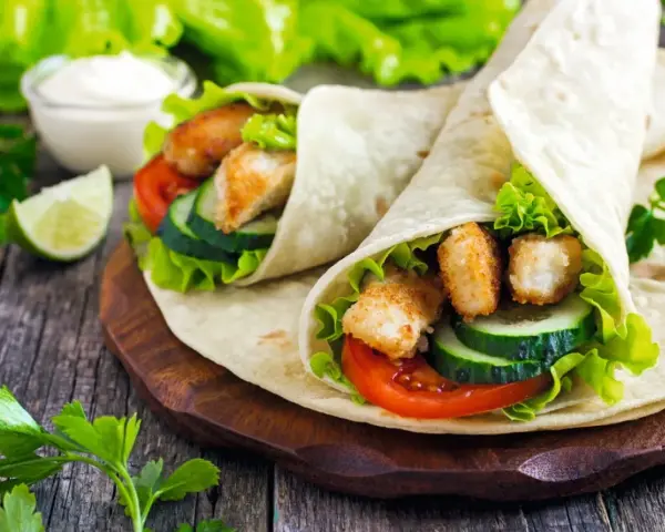 Tortilla z kurczakiem, pełna świeżych warzyw i chrupiącego kurczaka, wygląda pysznie. Lepsza niż domowa pizza!