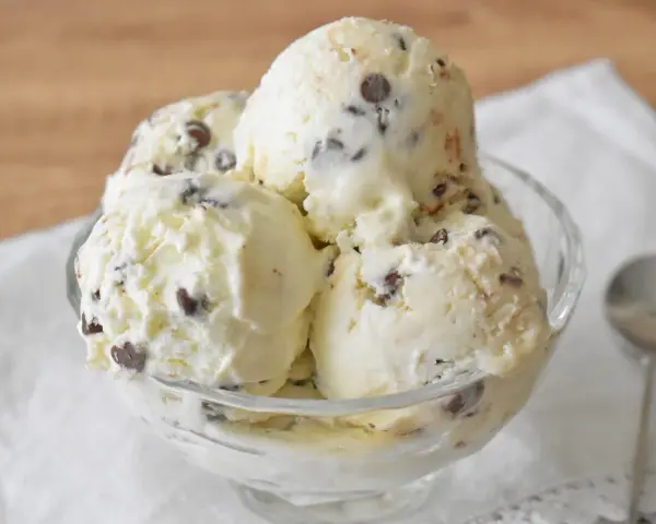 Pyszne lody straciatella w szklanej miseczce, pełne czekoladowych kawałków. Idealne na deser.