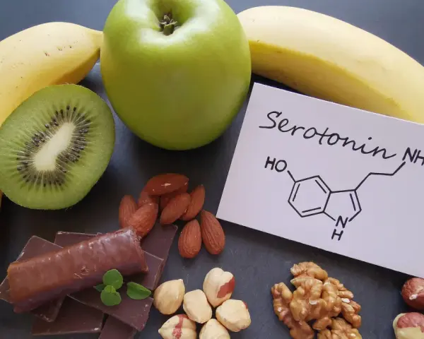 Banany, kiwi, jabłko, czekolada i orzechy. Na kartce wzór chemiczny serotoniny. W czym jest serotonina? W tych produktach!