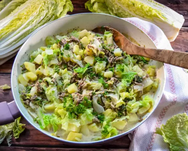Herzhaftes Chinakohl Rezept mit Hackfleisch und Kartoffeln in einer Pfanne, garniert mit Petersilie.