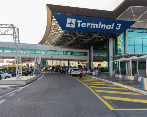 Wejście do Terminalu 3 lotniska Fiumicino z drogą dojazdową i samochodami.