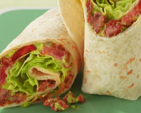 Zwei saftige wraps zum mitnehmen, gefüllt mit knackigem Salat, Tomaten und einer würzigen Fleischfüllung. Perfekt für unterwegs!