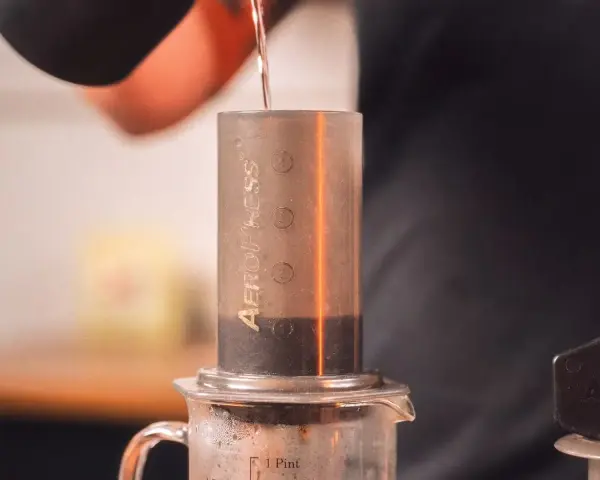 Przygotowanie kawy metodą aeropress cold brew. Woda powoli spływa do cylindra z kawą.