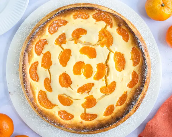 Ein goldbrauner, mit Mandarinen belegter Quarkkuchen, bestäubt mit Puderzucker. Dieser beste Mandarinen Quark Kuchen sieht köstlich aus!