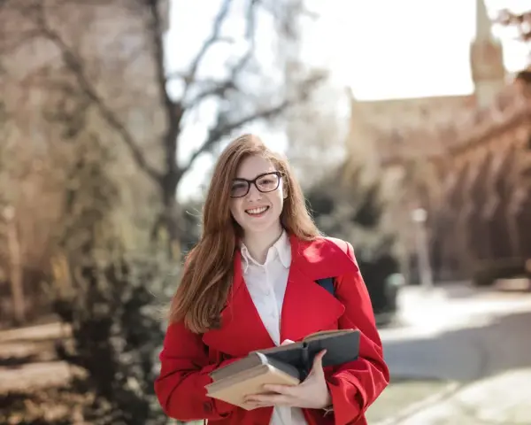 Junge Frau mit Büchern in der Hand, bereit für ihre Sprachreise. Die sprachreise kosten sind oft eine gute Investition in die Zukunft.