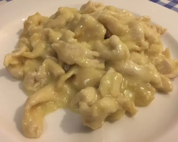 Straccetti di pollo al limone, un piatto cremoso e saporito, servito su un piatto bianco.